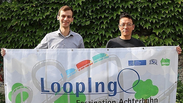 Daniel Ho & Kollege mit Banner "LoopIng - Faszination Achterbahn"